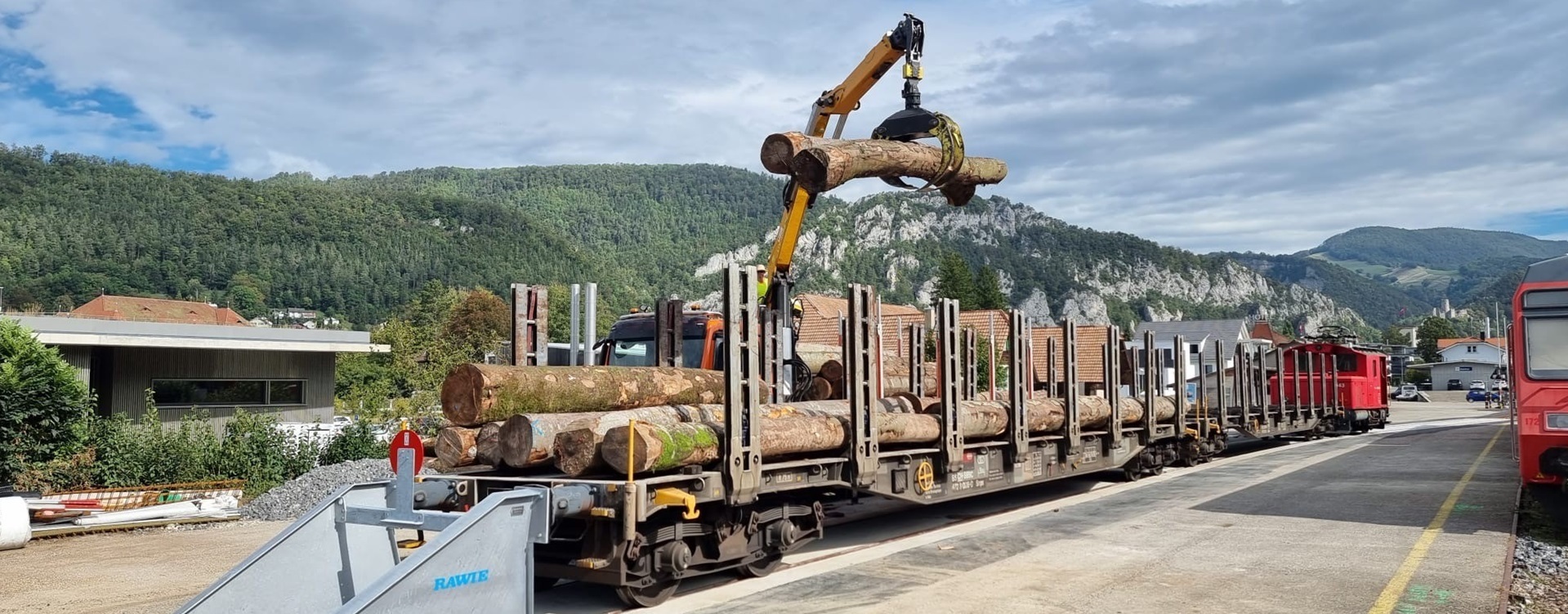 Holzhackschnitzel und Rundholz werden in Balsthal auf die Bahn verladen - Oensingen-Balsthal-Bahn AG